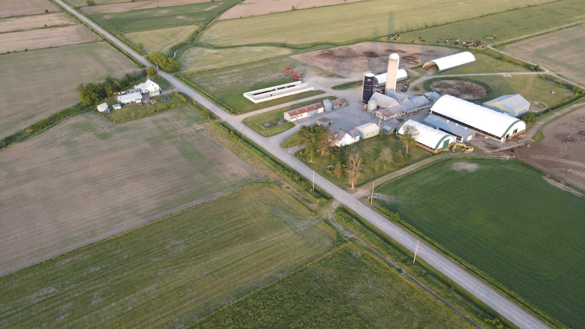 Aerial view of a rural farm surrounded by fields and roads.