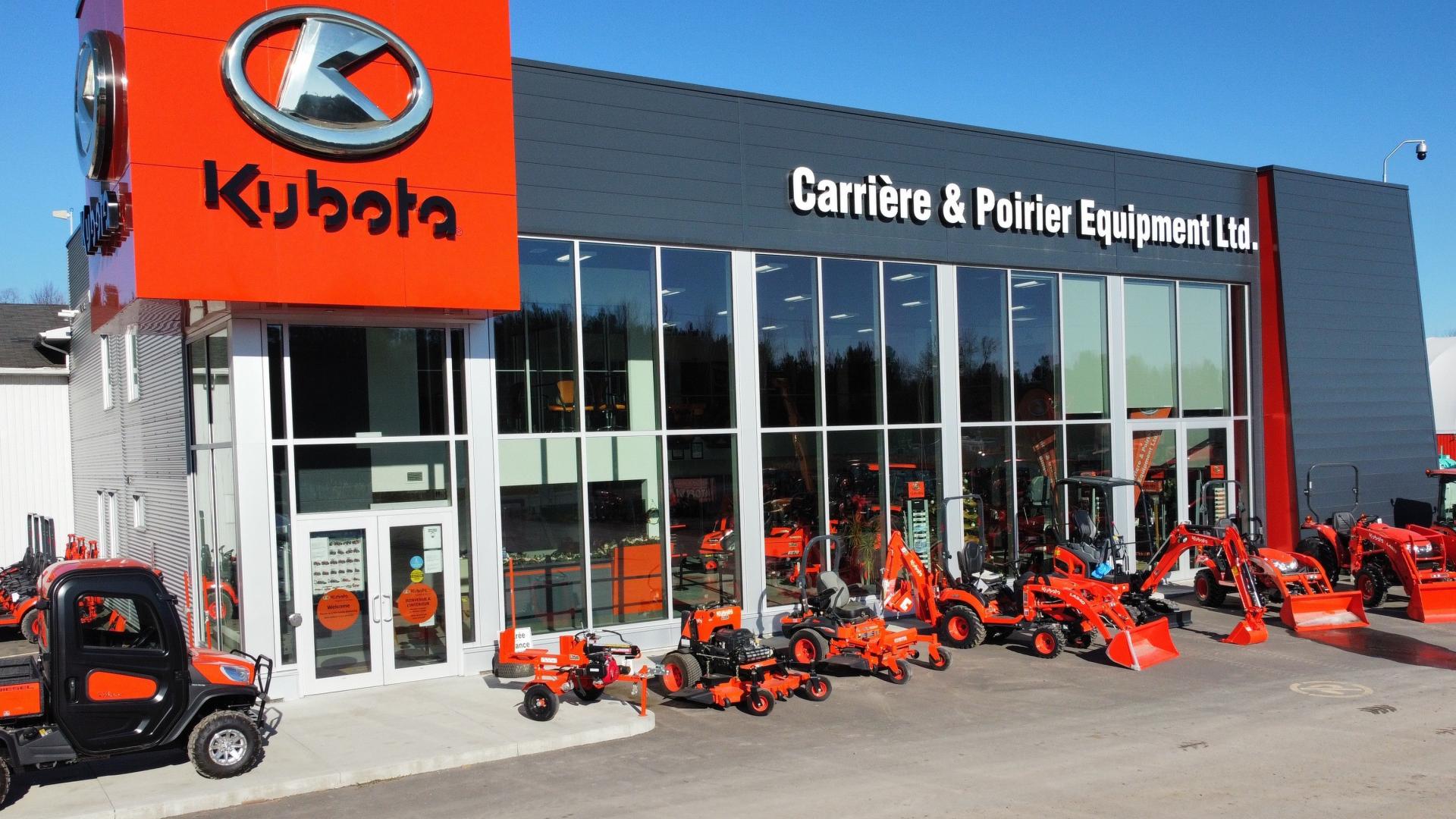 Kubota dealership with red tractors and equipment displayed outside.