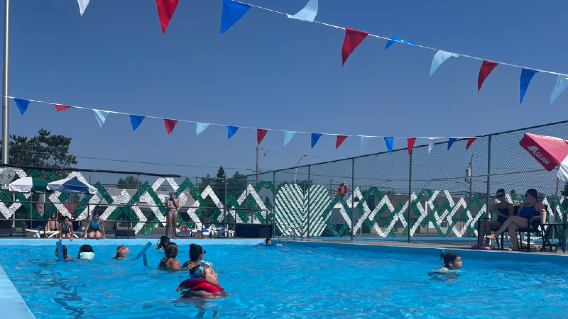 Piscine ensoleillé avec une dizaine d'enfants à l'intérieur