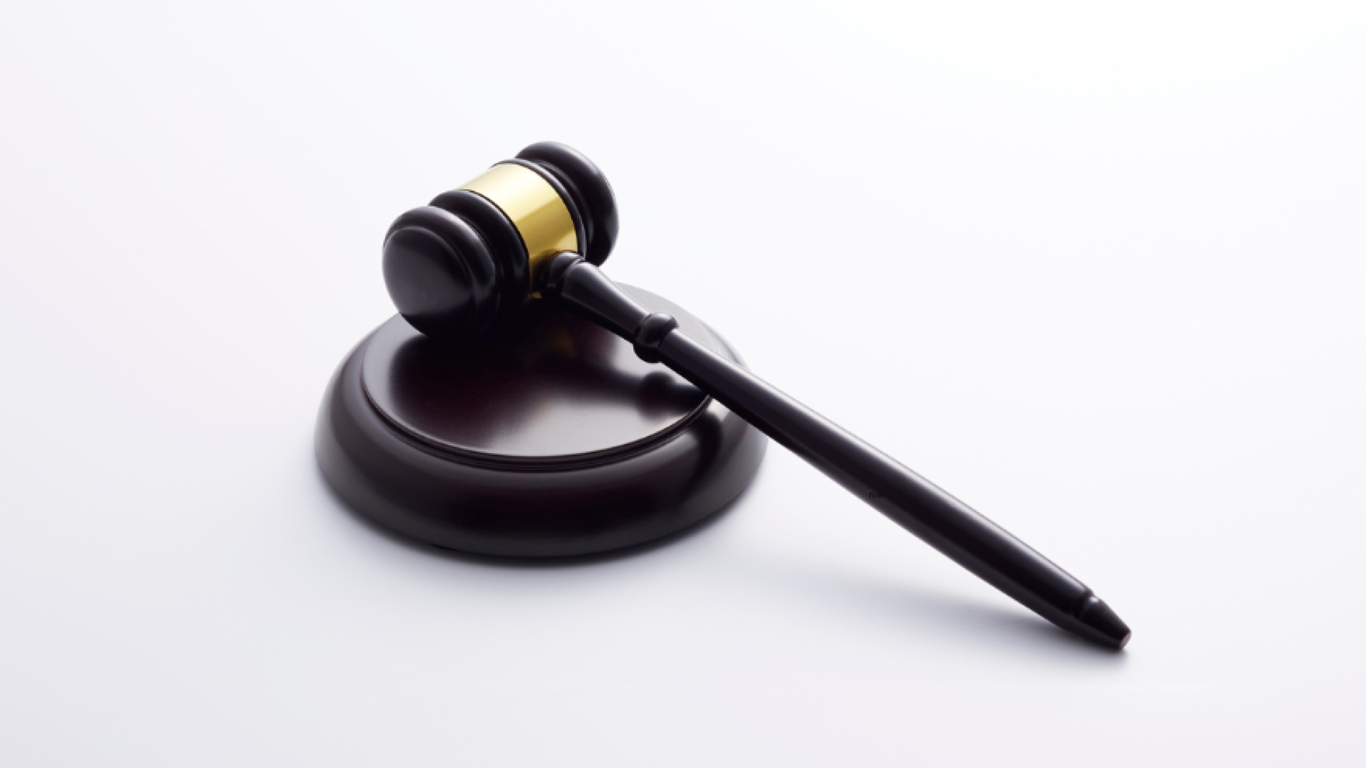 Black and gold gavel on a white background