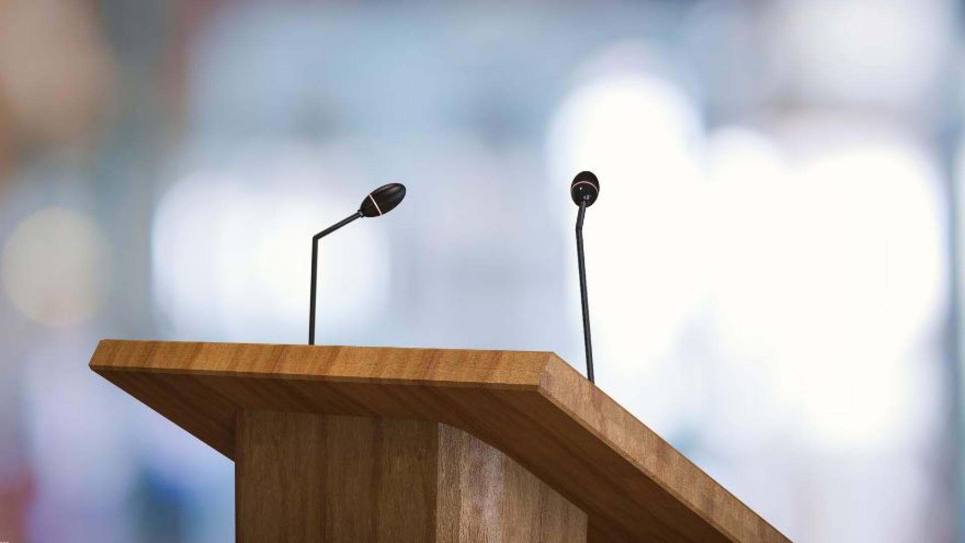 Close up of an empty lectern with microphones in an auditorium