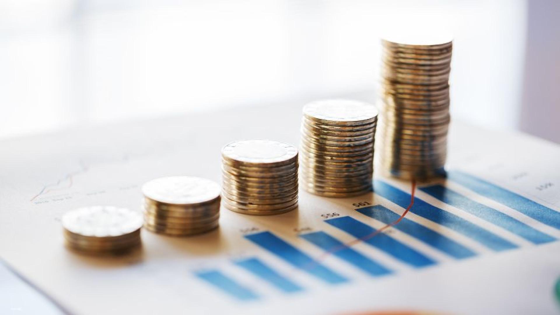 Different piles of coins on a printed graphic to represent finance