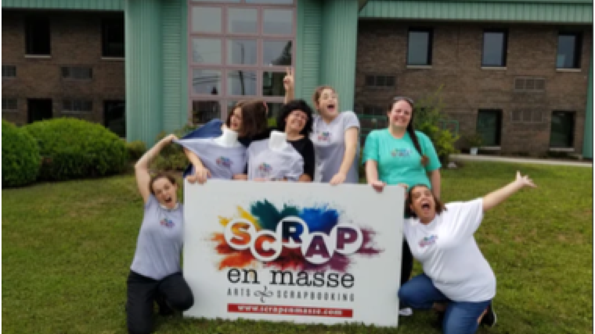 Group of six people happily posing with a "SCRAP on masse" sign outdoors.