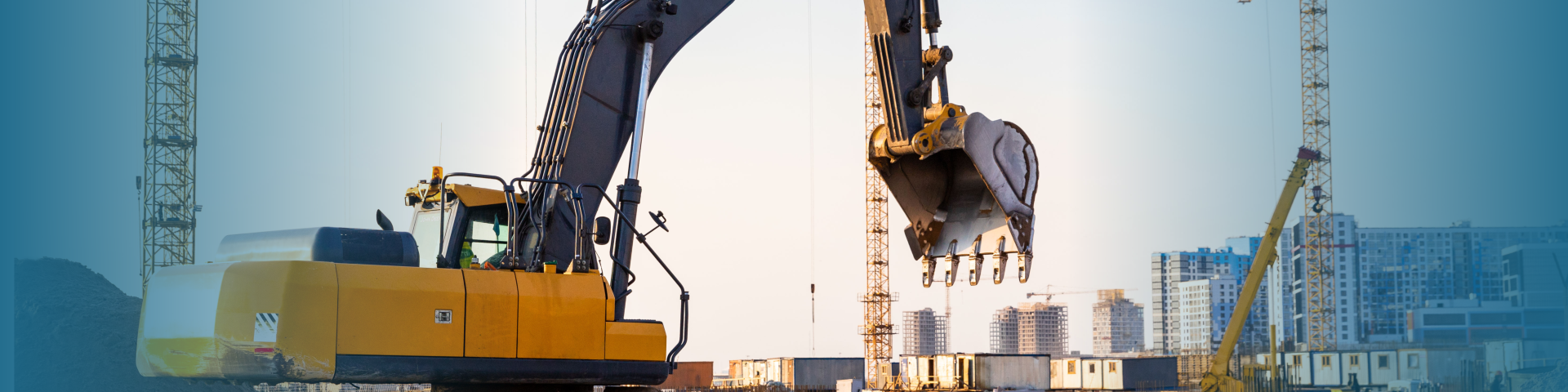 Large excavator at a construction site with cranes in the background.