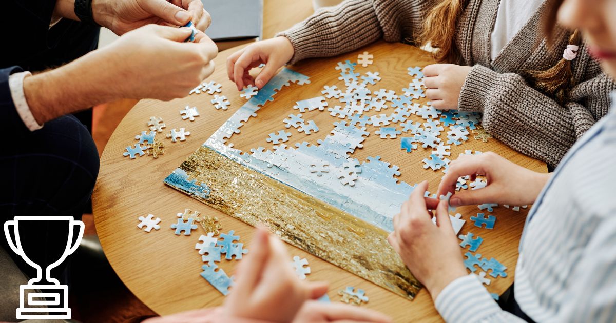 four pair of hands doing a puzzle 