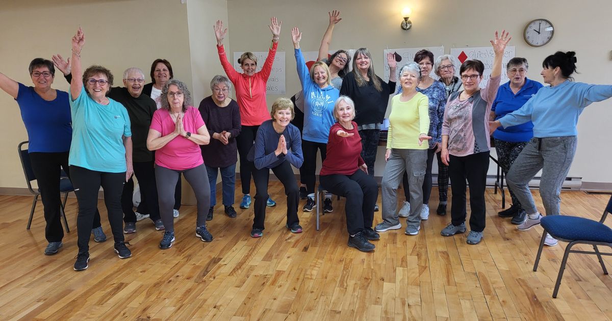 Groupe d'adultes plus âgés qui terminent leur session d'exercises en souriant. 