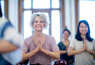 Older woman smilling while doing a yoga pose