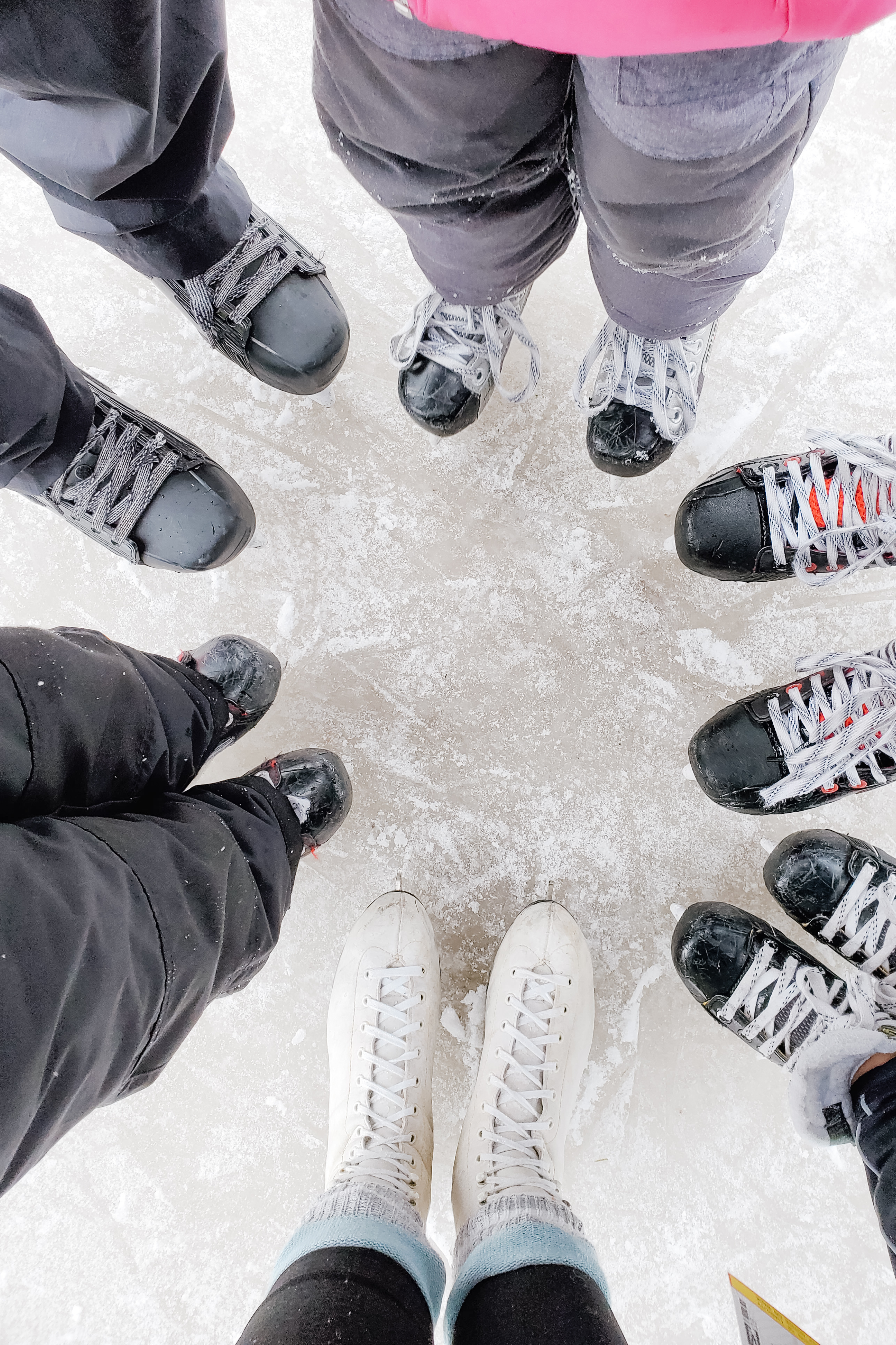 People gathered in a circle with a view of their skates. 