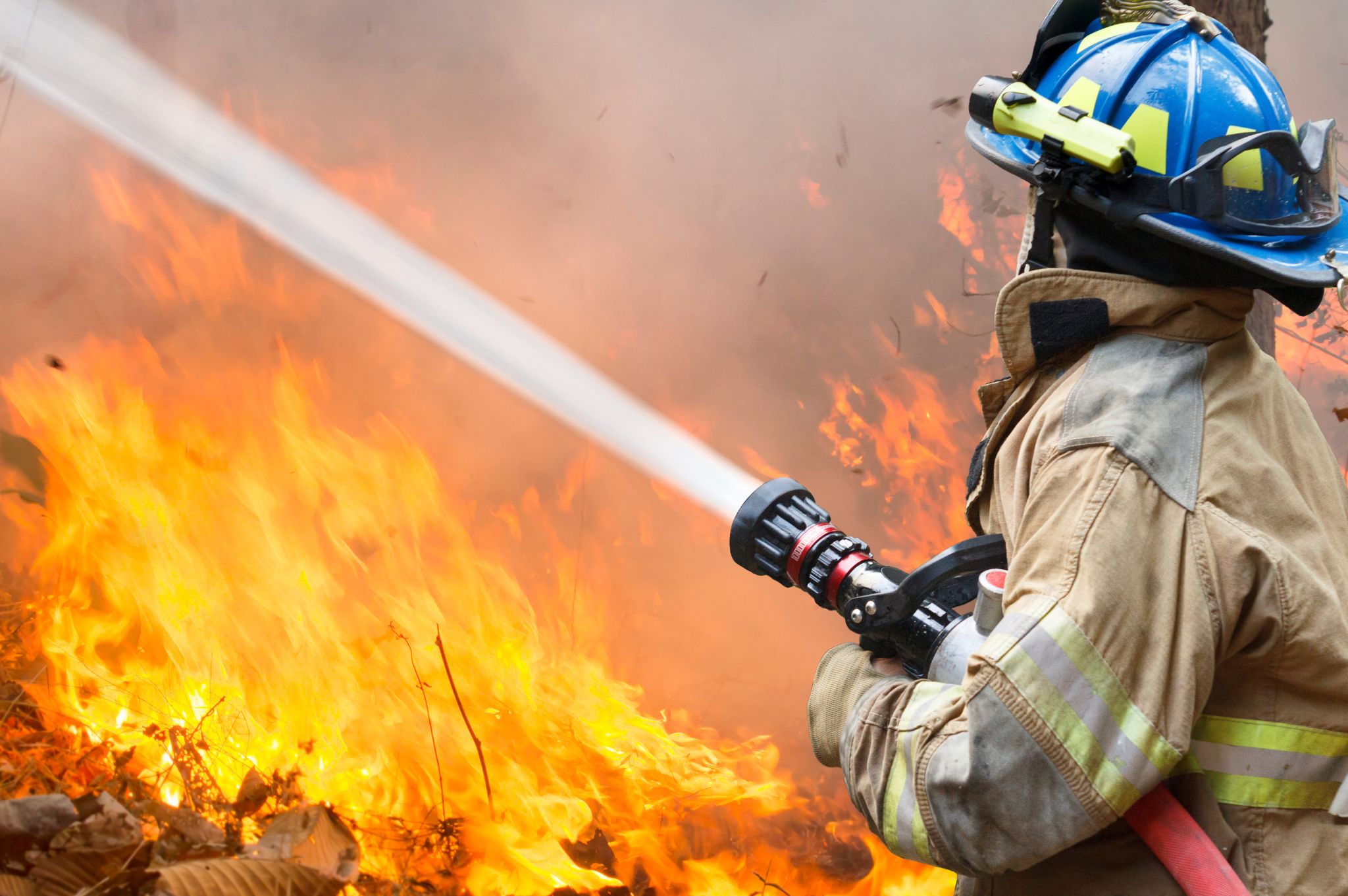 Un pompier qui arrose un feu