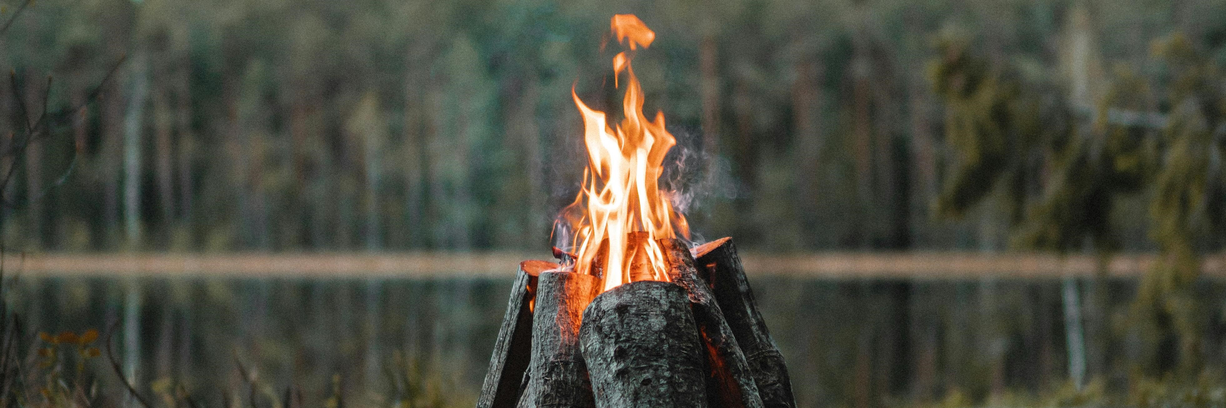 A camp fire on the side of the river
