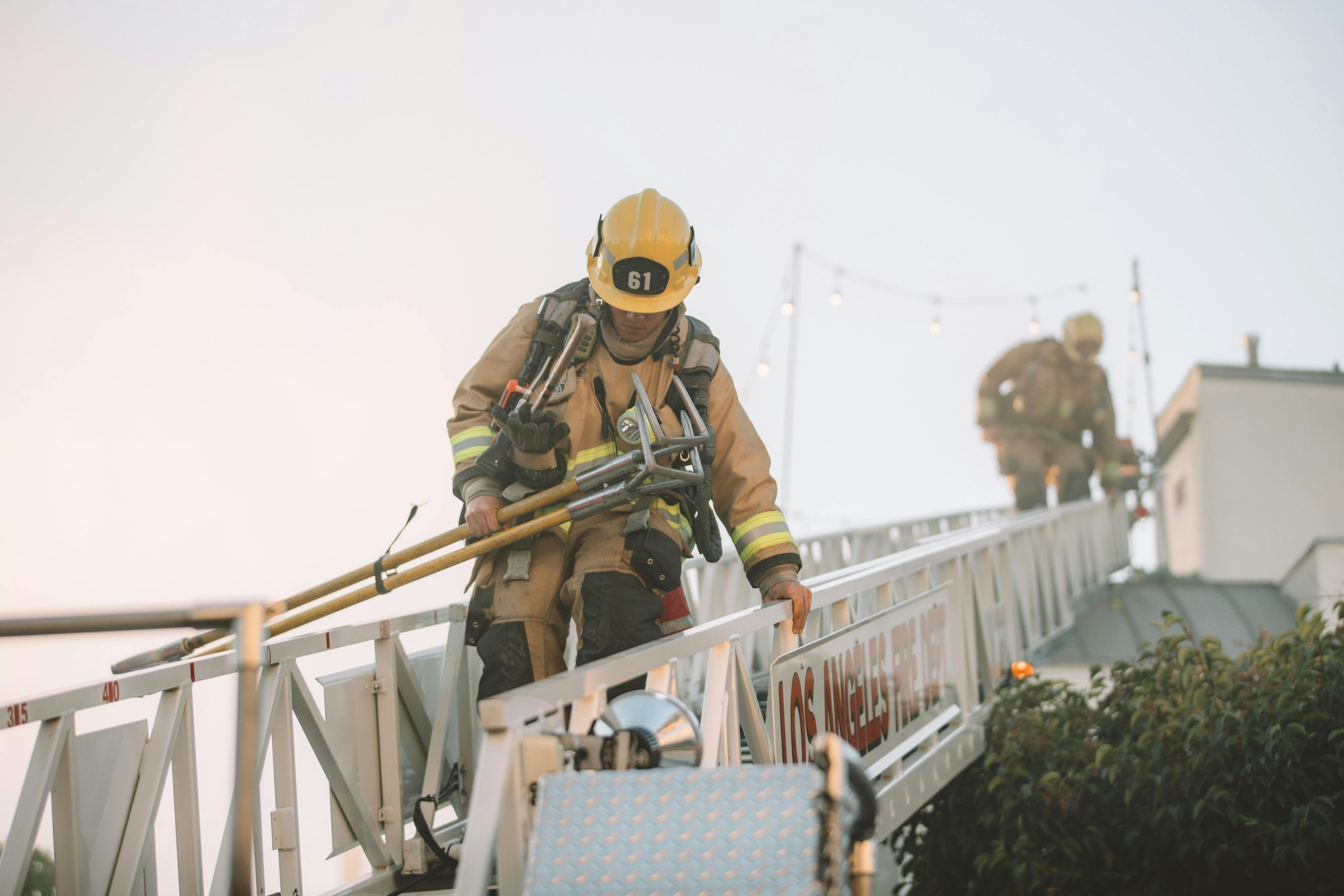 A volunteer Fire Fighter in a ladder with a partner behind him