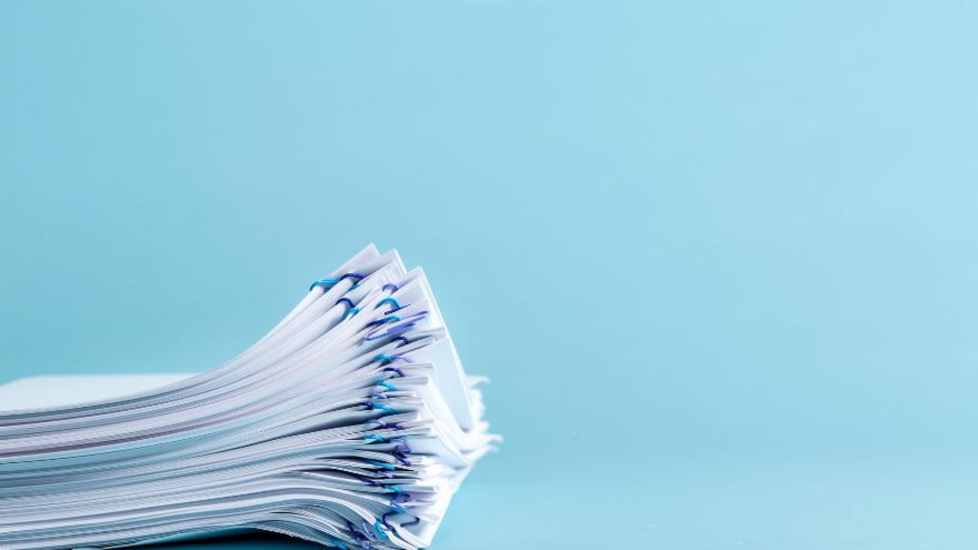 Pile of classified papers separated and held together with paper clips